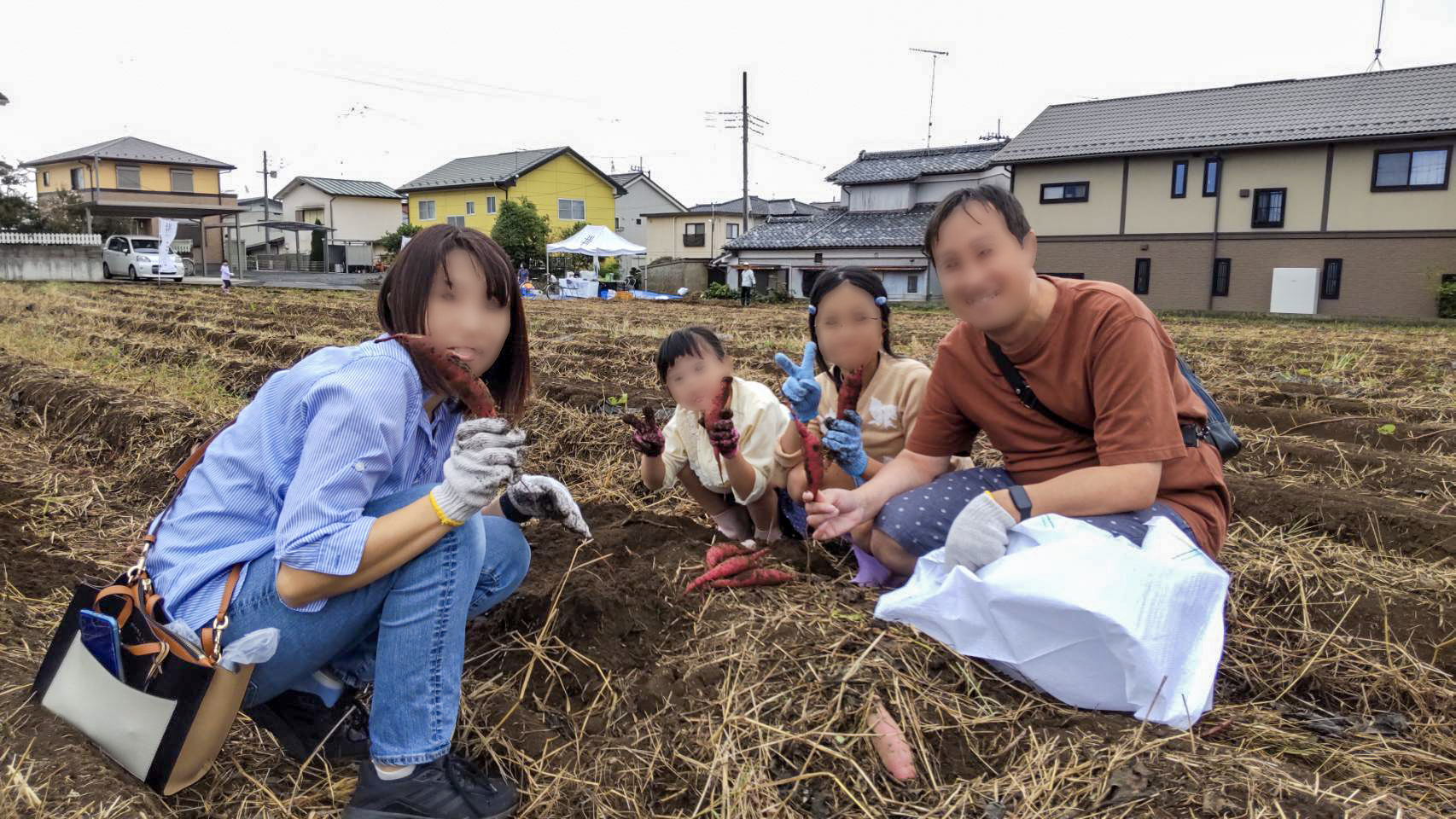 畑で収穫したさつまいもを手にするご家族